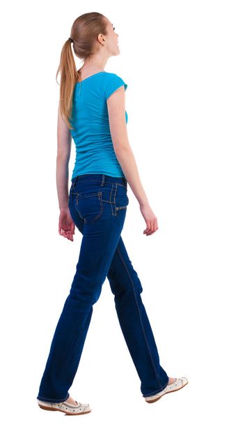 back view of walking woman in jeans and shirt. - Φωτογραφία, εικόνα