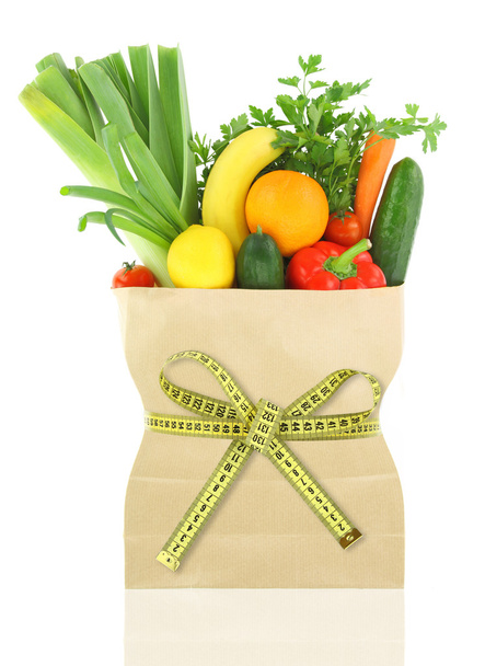 Verduras frescas y frutas en una bolsa de papel con cinta métrica
 - Foto, imagen