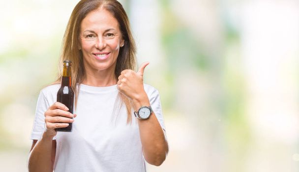 Mulher hispânica de meia idade bebendo cerveja sobre fundo isolado feliz com grande sorriso fazendo sinal ok, polegar com os dedos, excelente sinal
 - Foto, Imagem