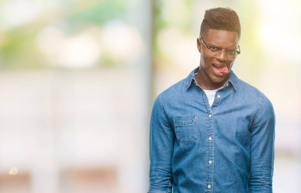 Young african american man over isolated background sticking tongue out happy with funny expression. Emotion concept. - Foto, Bild