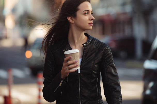Woman enjoying to walking with coffee cup in city street - Фото, зображення