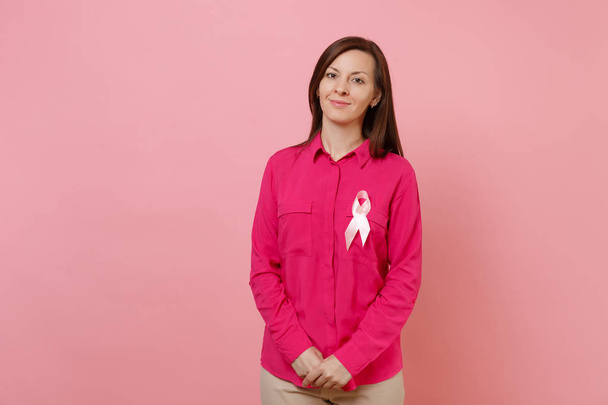 Woman in rose clothes with pink silk ribbon symbol isolated on pastel wall background, studio portrait. Medical healthcare gynecological oncology, Breast Cancer Awareness concept. Mock up copy space - Φωτογραφία, εικόνα