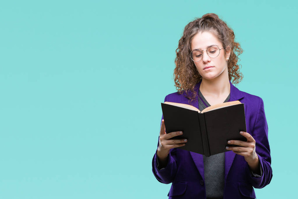 Young brunette student girl wearing school uniform reading a book over isolated background with a confident expression on smart face thinking serious - Foto, Imagen
