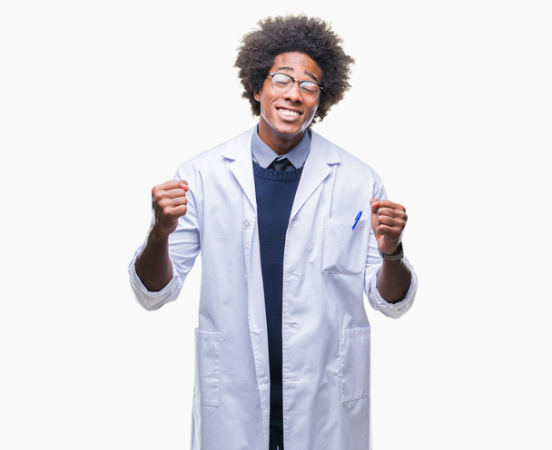 Afro Αμερικανός γιατρός επιστήμονας άνθρωπος πέρα από το απομονωμένο υπόβαθρο πολύ χαρούμενος και συγκινημένος κάνει νικητής χειρονομία με τα χέρια υψωμένα, χαμογελώντας και ουρλιάζοντας για την επιτυχία. Γιορτή έννοια. - Φωτογραφία, εικόνα