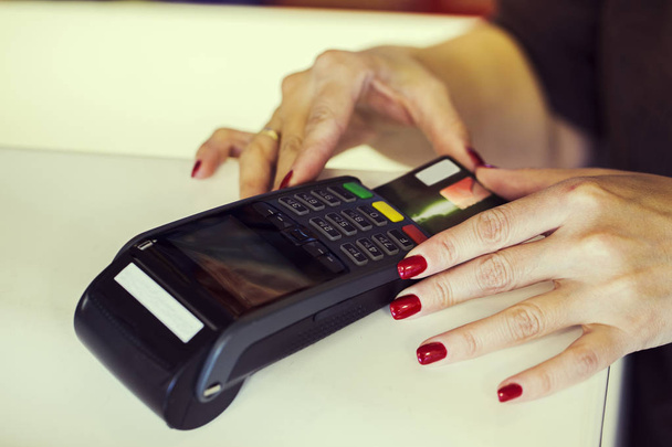 Bir mağaza desk içindeki kredi kartıyla şarj etmek için bir dataphone kullanarak bir satıcı el kapatın. Terminal bir mağaza. - Fotoğraf, Görsel