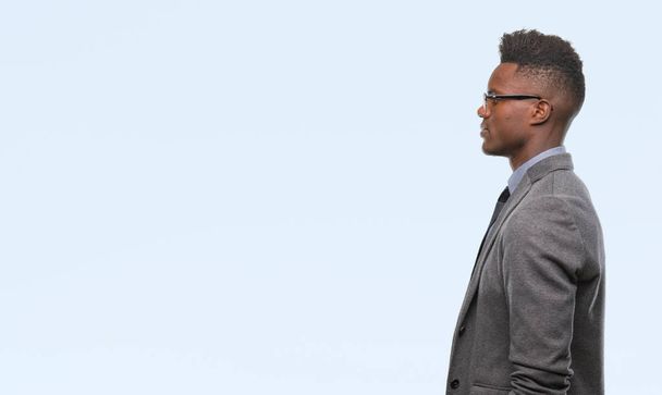 Mladí africké americké obchodní muž nad izolované pozadí pohledu na stranu, uvolnit profilu pozice s přirozenou tvář s sebejistý úsměv. - Fotografie, Obrázek
