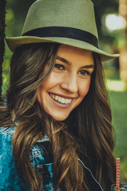 Nahaufnahme Porträt eines jungen Mädchens mit Hut und einem schönen Lächeln an einem Sommertag - Foto, Bild