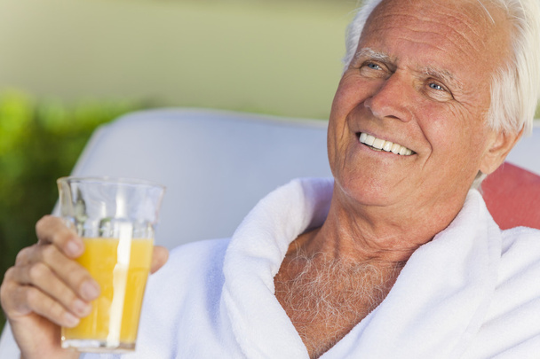 Uomo anziano in accappatoio bere succo d'arancia
 - Foto, immagini