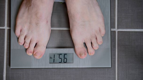 Männliche Füße auf Glaswaagen, Männerernährung, Körpergewicht - Foto, Bild