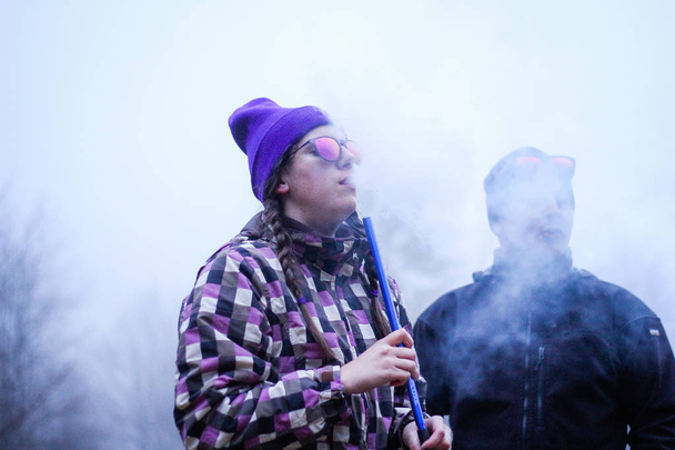 The girl exhales the smoke. Smoking hookah Traveler Ukrainian Carpathian Mountains. Traveling - Photo, image