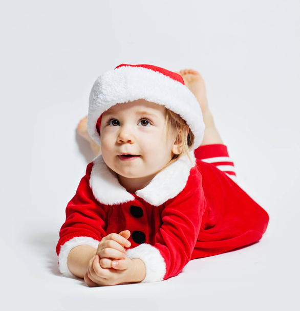Smiling baby in Santa hat on white background, Christmas portrait - Photo, Image
