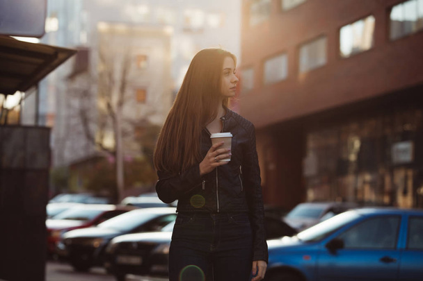 Mujer disfrutando de caminar con taza de café en la calle de la ciudad
 - Foto, Imagen