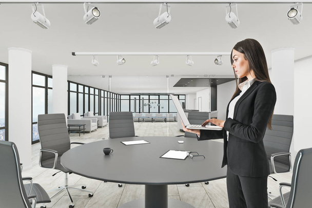 Pretty businesswoman using laptop in modern meeting room interior. 3D Rendering  - Фото, зображення