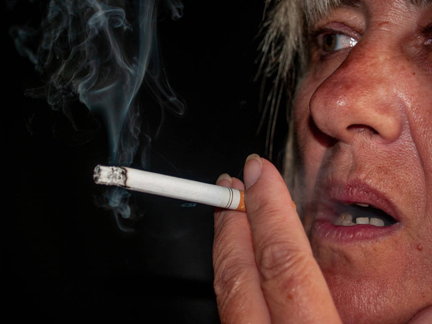 A mature woman smoking a cigarette - Photo, Image