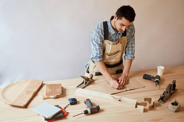 Carpenter man making draft plan using pencil on the table with tools - Фото, изображение