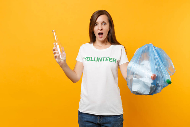 Женщина в футболке волонтер, мешок для мусора изолирован на жёлтом фоне. Добровольная бесплатная помощь, благотворительность. Проблема загрязнения окружающей среды. Остановить природоохранную концепцию
 - Фото, изображение