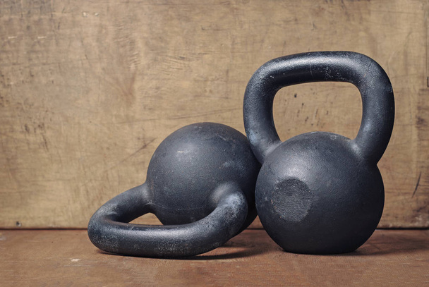 two heavy kettlebell black on wooden background - Photo, Image