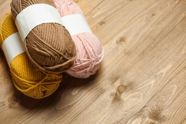 красочные шерстяные нити для вязания на деревянном фоне
 - Фото, изображение