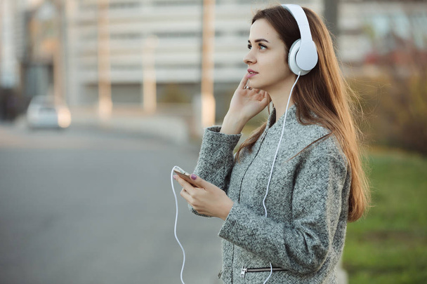 Mulher ouvindo música com fones de ouvido na cidade
 - Foto, Imagem