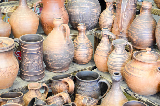 Natural traditional clay pottery beautiful old kitchen appliances, dishes, jugs, vases, pots, mugs. The background - Photo, Image