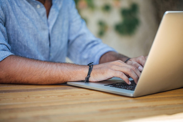 Hands of unrecognisable businessman typing on his laptop outdoors. - Fotó, kép
