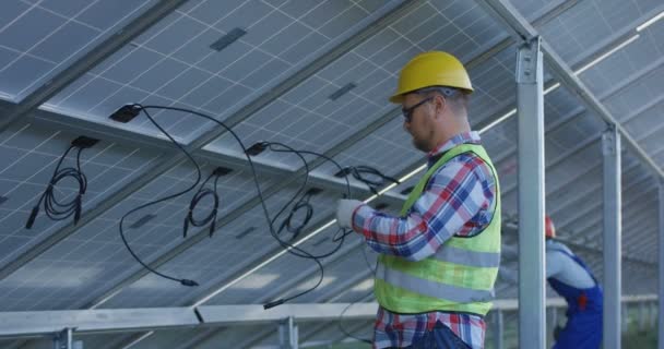 Workers connecting wires of solar panels - Footage, Video