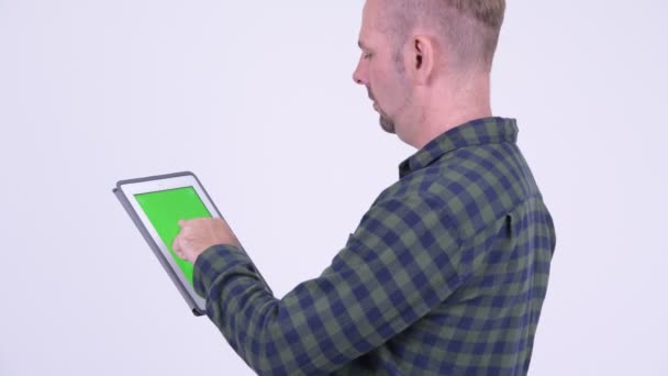 Profile view of blonde hipster man using digital tablet - Filmmaterial, Video