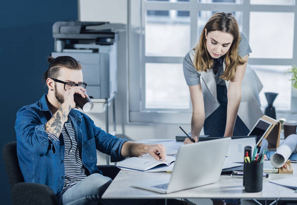 Young businessman and businesswoman working together at modern office. - Zdjęcie, obraz