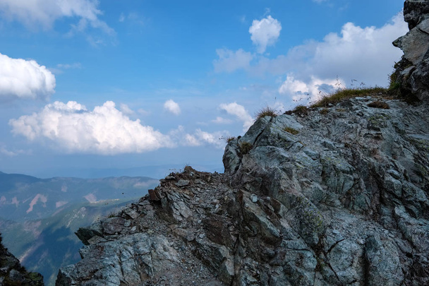 Bergpanorama vom Gipfel des Banikov-Gipfels in der slowakischen Tatra mit felsiger Landschaft und Schatten der Wanderer bei hellem Tag mit herannahenden Gewitterwolken - Foto, Bild