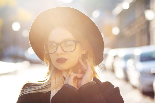 Closeup street portrait of stylish blonde woman with red lips wearing glasses and hat. Space for text - Foto, afbeelding