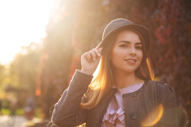 wunderschönes lächelndes Mädchen mit natürlichem Make-up, das Hut trägt und warmes Herbstwetter genießt. Raum für Text - Foto, Bild