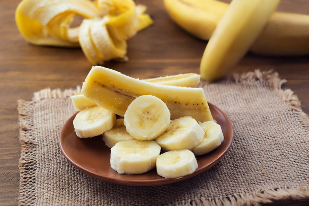 Banana madura descascada, cortada longitudinalmente e transversalmente em pedaços
. - Foto, Imagem