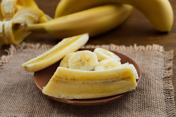 Cortado longitudinalmente e transversalmente banana madura, descascada
. - Foto, Imagem