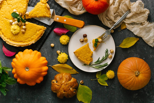 Нарезанный свежий тыквенный пирог с орехами и мятой, украшенный желтыми цветами
 - Фото, изображение