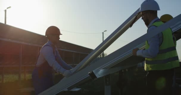 3 人の労働者は、ソーラー パネルを設置します。 - 映像、動画