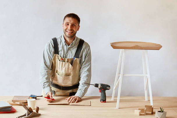 Hombre carpintero haciendo borrador plan usando lápiz sobre la mesa con herramientas
 - Foto, imagen