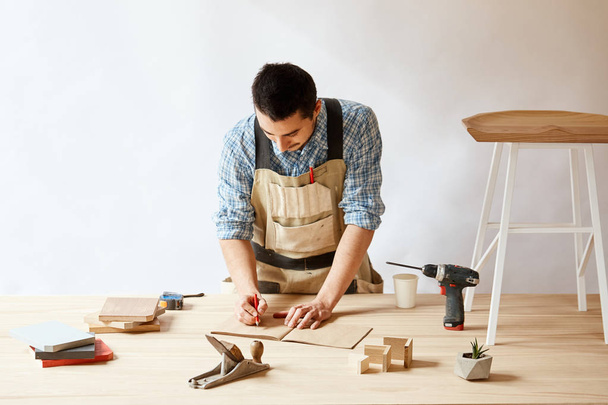 Carpenter man making draft plan using pencil on the table with tools - Foto, Imagem
