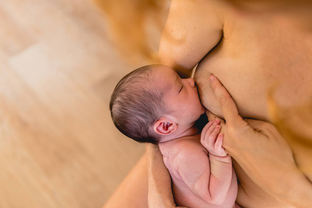 Молодая женщина кормит младенца грудью
. - Фото, изображение