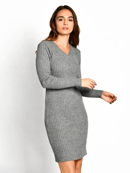 Young beautiful woman posing in new gray fashion winter knitted dress smiling - Fotó, kép
