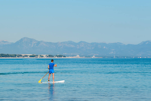 Stand up paddle boarding, back man floating on SUP board, adventure of sea with blue water on a surfing - Foto, Bild