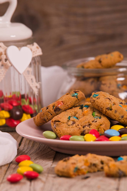 Candy coated cookies on wooden table. - Photo, Image
