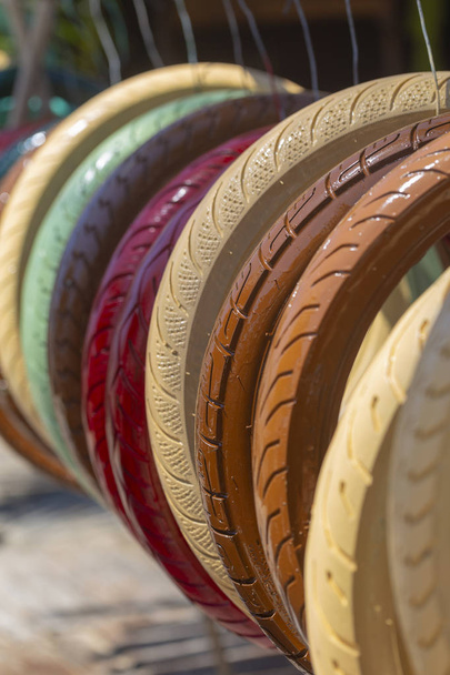 multi-colored painted tires from cars, motorbikes, scenery on the beach - Photo, Image