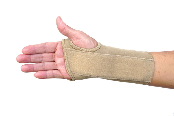 Old female hand wearing hand wrist therapy support glove isolated on white                                - Photo, Image