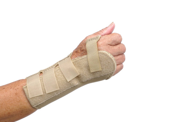 Vieille main féminine portant un gant de soutien de thérapie de poignet de main isolé sur blanc
                                 - Photo, image