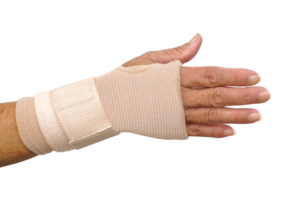 Old female hand wearing hand wrist therapy support glove isolated on white                                  - Photo, Image