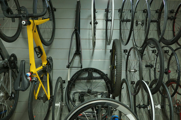 Vélos et roues suspendus au mur / Magasin de vélos et accessoires concept
 - Photo, image