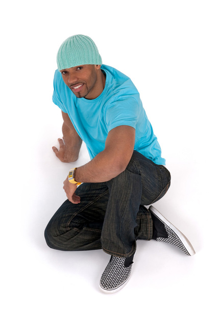 Hombre joven y relajado en una camiseta azul sentado en el suelo
 - Foto, Imagen