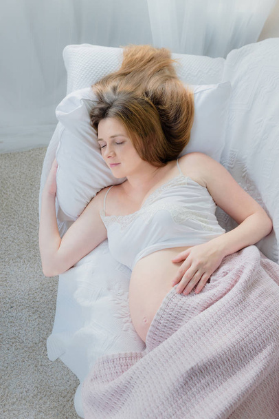 joven embarazada durmiendo en sofá
  - Foto, imagen