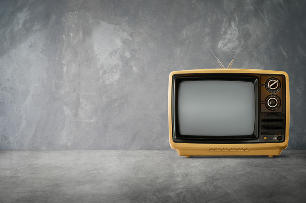 Amarillo Naranja color viejo vintage retro Televisión sobre mesa de cemento con fondo
 - Foto, Imagen
