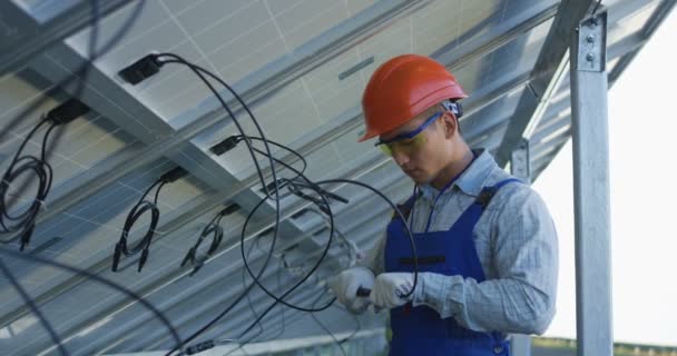 Trabajadores que conectan cables de paneles solares
 - Imágenes, Vídeo